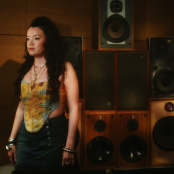 Musician Clementine Douglas standing in front of speakers